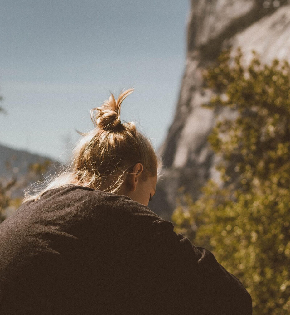 Woman sitting outside with trees in the background